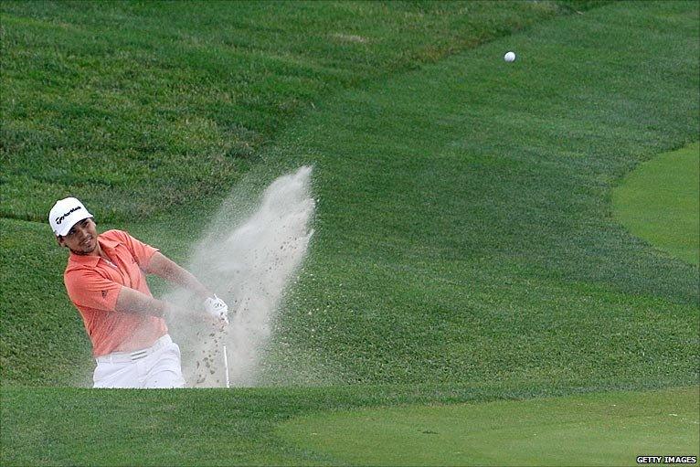 Jason Day plays a bunker shot on 18