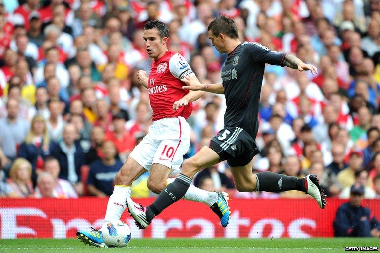 Robin van Persie is challenged by Daniel Agger