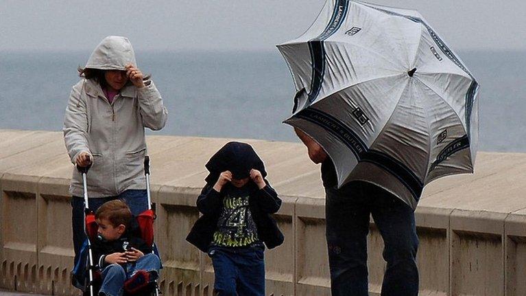 Family battling winds during bad summer weather in Scarborough