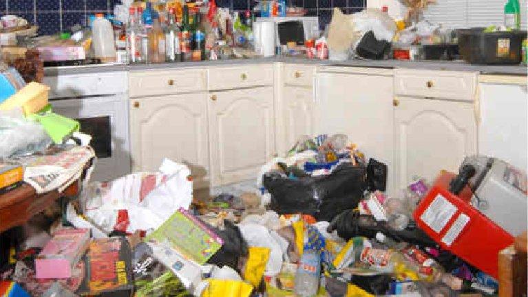 The kitchen in Amanda Hutton's house, with rubbish on the floor and several drink bottles