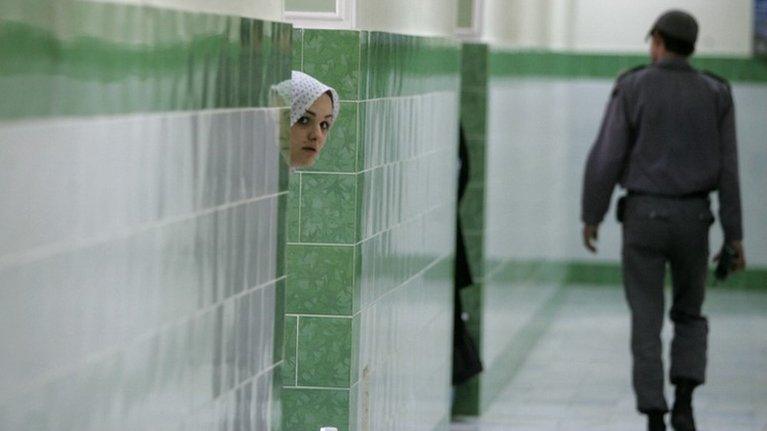 An inmate looks out the door of a cell at Tehran's Evin prison (13 June 2006)