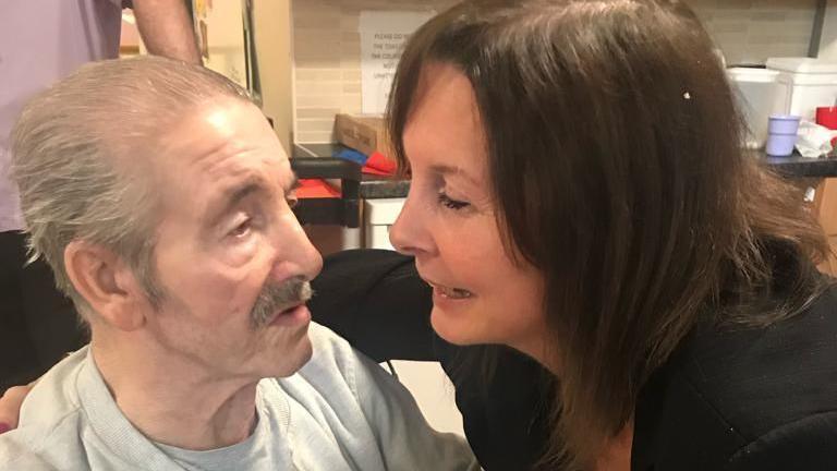 Vince Pettitt and his daughter, Jane Roche looking at each other. Her arm is around his shoulder.