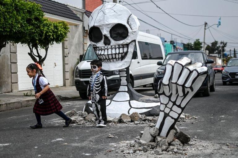 Children pose next to the cardboard skeleton