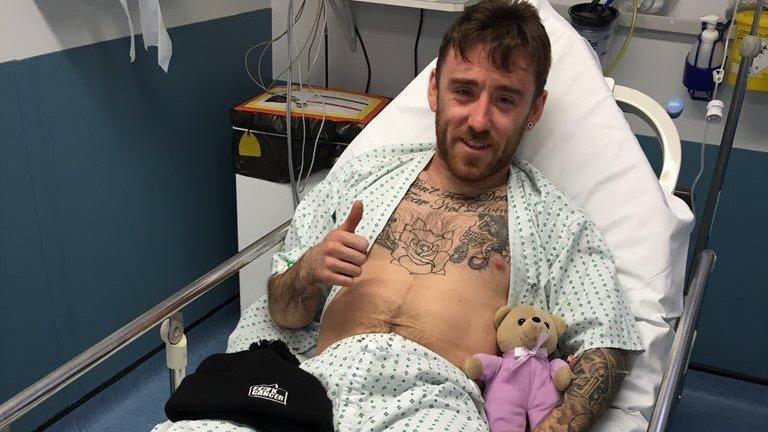 Lee Johnston gives the thumbs up as he is treated in hospital following Sunday's crash