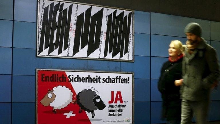 Posters against (above) and for (below) the Swiss Enforcement Initiative at a railway station in Zurich