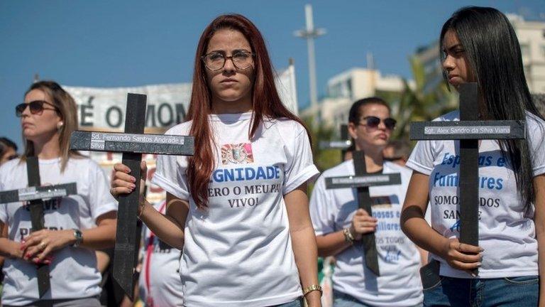 Relatives of police officers hold crosses as they protest the death of 91 members of the security forces since the beginning of 2017 at Copacabana beach, in Rio de Janeiro, Brazil, on July 23, 2017