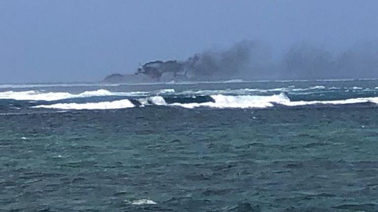 Smoke seen rising from the capsized HMNZS Manawanui