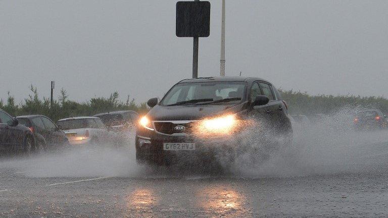 A car makes its way through heavy rain on Brighton seafront