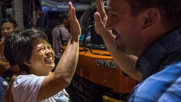 Onlookers at the junction in front of Chiangrai Prachanukroh Hospital watch and cheer as ambulances transport the last rescued schoolboys and their coach from a helipad nearby on July 10, 2018