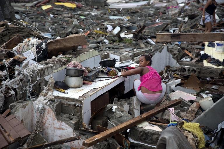 Woman searching through rubble