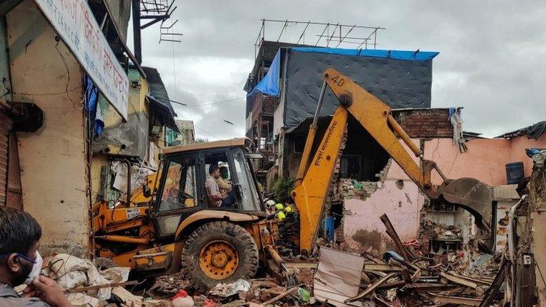 Rescue workers search for survivors in the debris after a residential building collapsed in Mumbai, India, June 10, 2021