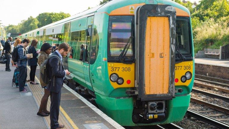 Commuters queue to get on a Southern train