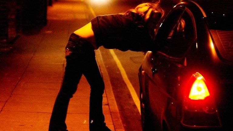 A girl talks to a driver through the car window