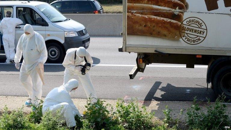 Forensic experts investigate a truck in which refugees were found dead as it stands on A4 between Parndorf and Neusiedl, Austria, 27 August 2015