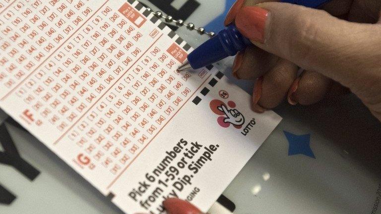 Person fills out National Lottery ticket