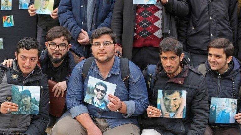 University of Tehran students hold pictures of victims during a memorial after the plane crash