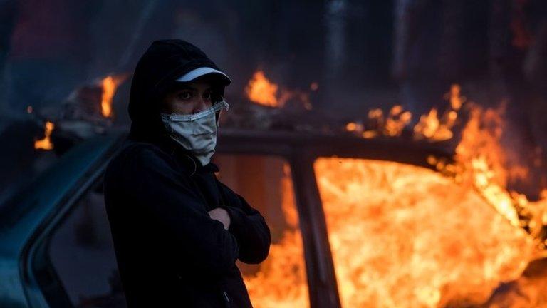 People demonstrate in the vicinity of a members of the Bolivarian National Guard command, in Caracas, Venezuela, 21 January 2019.