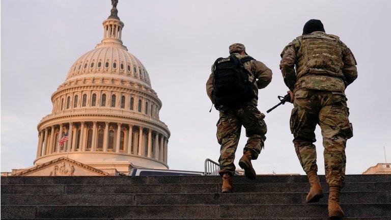 National Guard members walk at the Capitol in Washington on January 15, 2021