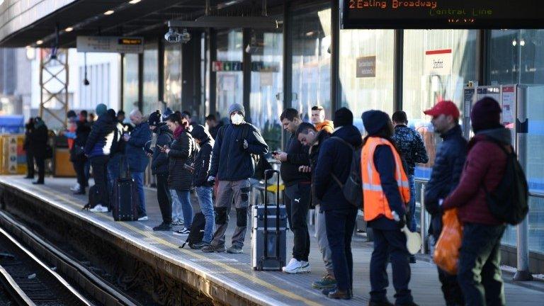 Tube users wait for a train