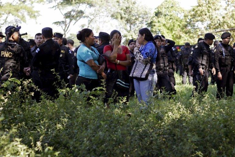 Family members of inmates and police officers stand outside a prison in Escuintla, Guatemala, November 30, 3015.