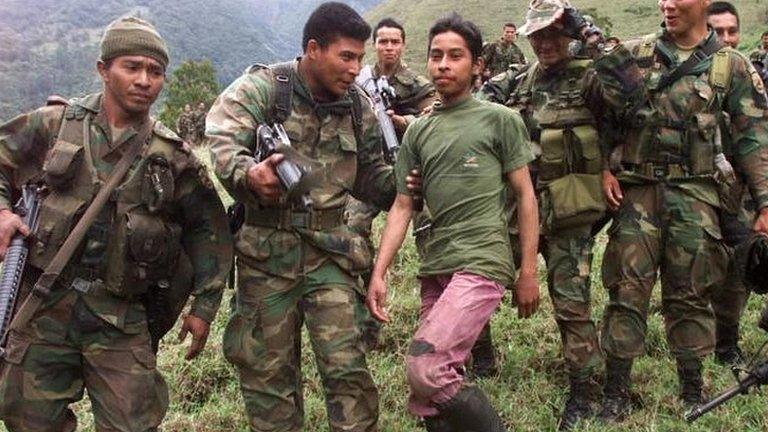 Soldiers escort a 13-year-old captured teenage rebel of the Farc in the mountains of Santander state on 21 December, 2000.