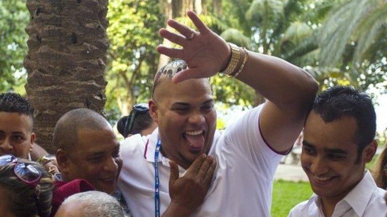 St. Louis Cardinals catcher Brayan Pena raises his arm to greet someone as he reunites with family members, including his grandmother Rosa de las Nives, 85, bottom left, at the Hotel Nacional in Havana, Cuba, Tuesday, Dec. 15, 2015