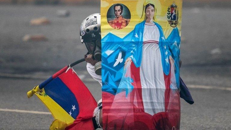 An opposition protester hides behind a handmade shield during a protest in Caracas, Venezuela, 07 June 2017.