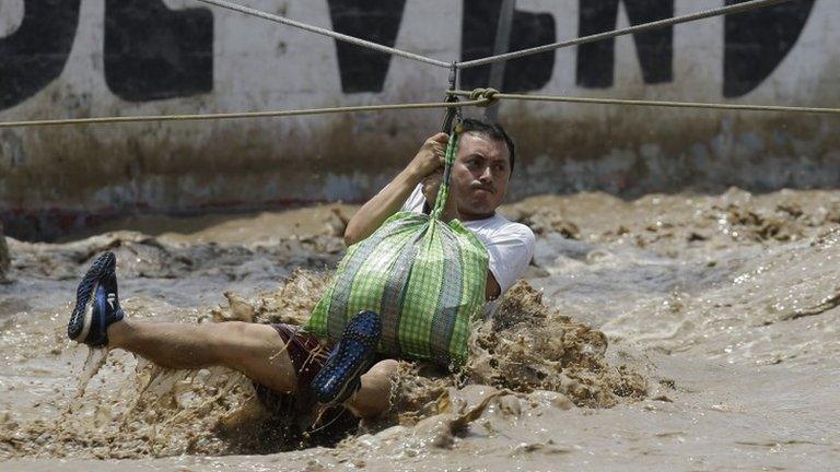 Man is rescued in a zipline harness in Lima, Peru, Friday, March 17, 2017