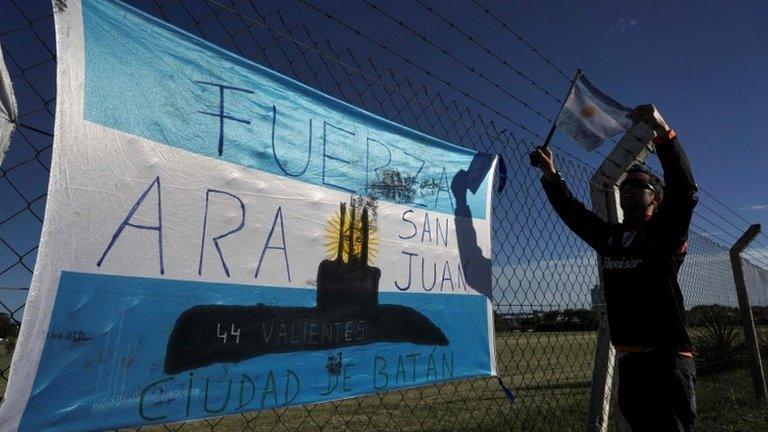 A man hangs an Argentinian flag outside Argentina"s Navy base in Mar del Plata, on the Atlantic coast south of Buenos Aires, on November 22, 2017.