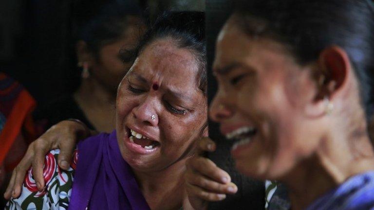 Relatives of Lata Jadhav, one among the dozens who died after drinking tainted liquor, cry during her funeral in Mumbai, India, Sunday, June 21, 2015.