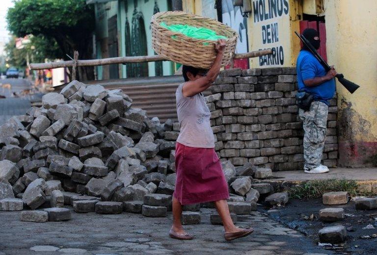 A local resident walks past a pro-government supporter after clashes with demonstrators in the indigenous community of Monimbo in Masaya, Nicaragua July 17, 2018