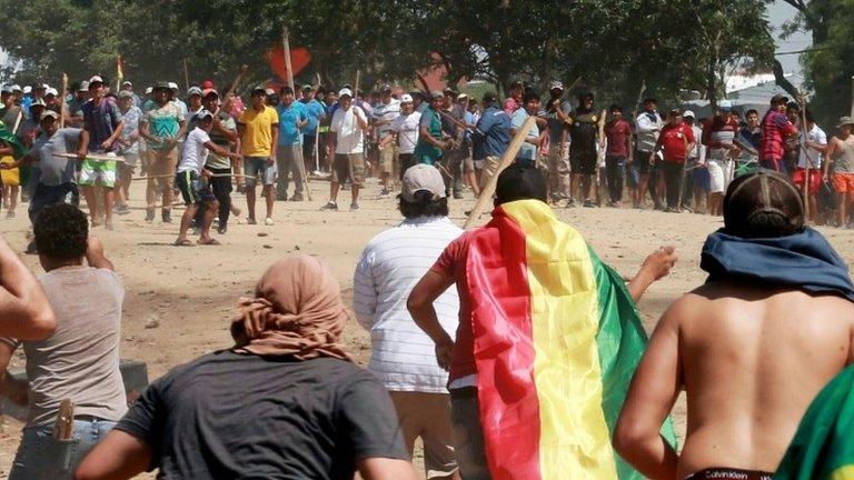 Supporters (background) of Bolivian President Evo Morales and supporters of opposition presidential candidate Carlos Mesa clash in La Guardia on 24 October 2019