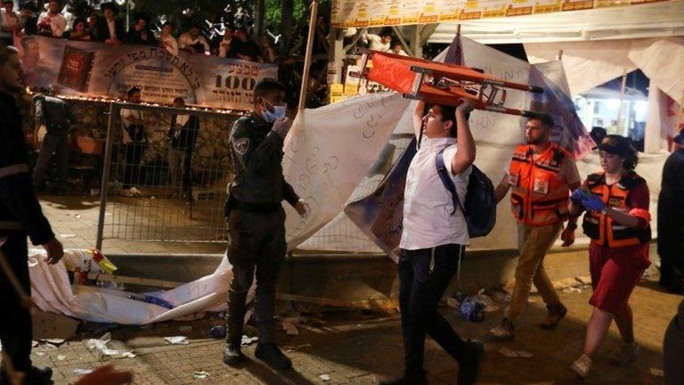 A man carries a stretcher after a crush at the Lag B'Omer festival