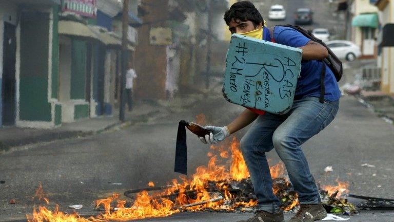 A student demonstrator prepares to throw a Molotov cocktail as they clash with the police during a protest against President Nicolas Maduro's government in San Cristobal, Venezuela March 2, 2016.