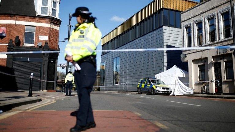 Police officers stand guard at the scene where a man died from stab wounds