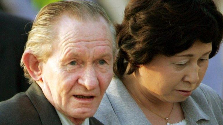 Ex US army sergeant Charles Robert Jenkins is escorted by his Japanese wife Hitomi Soga as they arrive at Tokyo's Haneda airport on 18 July 2004 after being reunited in Jakarta.