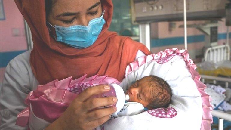 A nurse feeds a newborn baby rescued and brought to Ataturk Children hospital, after the mother was killed during a gunmen attack on a maternity hospital, in Kabul on May 15, 2020.