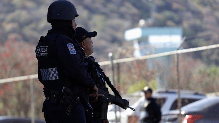 Police officers stand guard outside the Reclusorio Sur prison after three prisoners wanted by the United States for their links to drug trafficking, escaped.