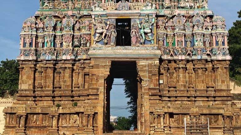 The base of a tall stone temple, above the entrance our colourful carved religious scenes.
