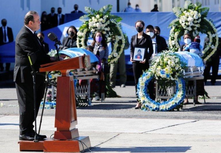 Guatemala's President Alejandro Giammattei speaks as relatives of the 14 Guatemalan migrants, who were killed in in the Mexican state of Tamaulipas while trying to reach the U.S., attend a funeral ceremony during the repatriation of the bodies, at the Guatemalan Air Force, in Guatemala City, Guatemala March 12, 2021.