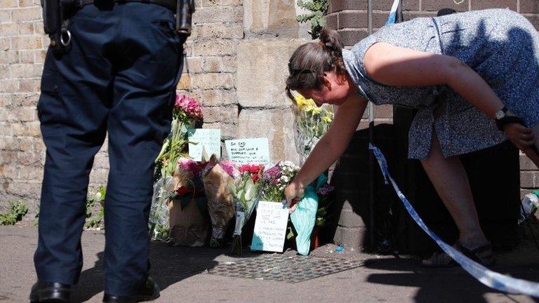 Woman lays flowers in Finsbury Park