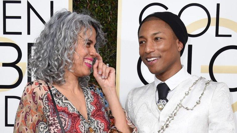 Pharrell Williams (right) and Mimi Valdes arrive at the 74th annual Golden Globe Awards, January 8, 2017, at the Beverly Hilton Hotel in Beverly Hills, California.