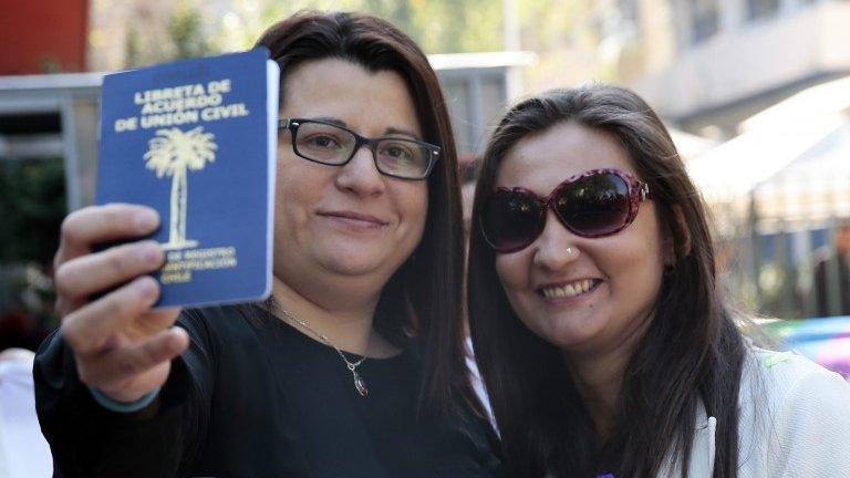 Roxana Ortiz (L) and Virginia Gomez (R) show their civil union agreement card after formalising their union in Santiago (22/10/2015)