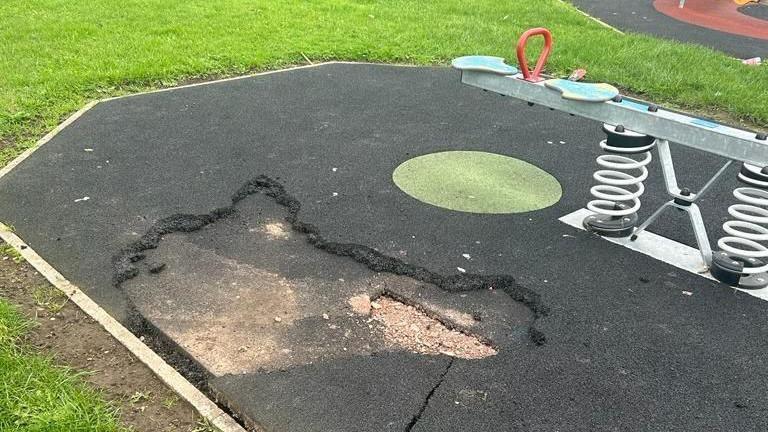 Protective surface in children's playground ripped up