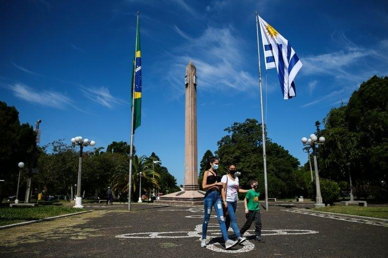 People walk on the International Square, amid the coronavirus disease (COVID-19) pandemic, at the border of Brazilian city Santana do Livramento and Uruguayan city of Rivera, Uruguay March 19, 2021