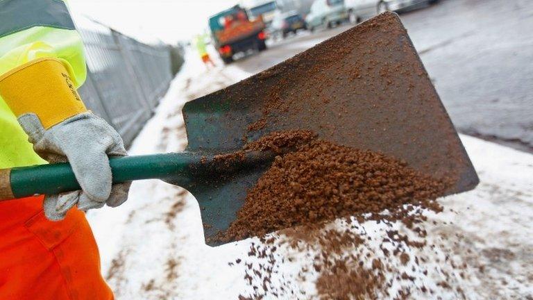 Council worker spreading grit