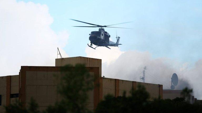 A Salvadoran army helicopter flies over the ministry of treasury building during a blaze in San Salvador, El Salvador, July 7, 2017.