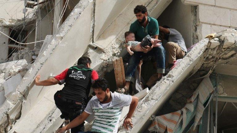 Syrian men remove a baby from the rubble of a destroyed building following a reported air strike in the Qatarji neighbourhood of the northern city of Aleppo (September 21, 2016)