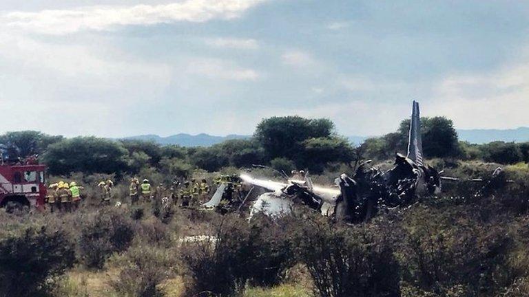 Handout picture released by Durango"s Civil Protection showing firemen working at the wreckage of a plane that crashed with 97 passengers and four crew on board on take off at the airport of Durango, in northern Mexico, on July 31, 2018.