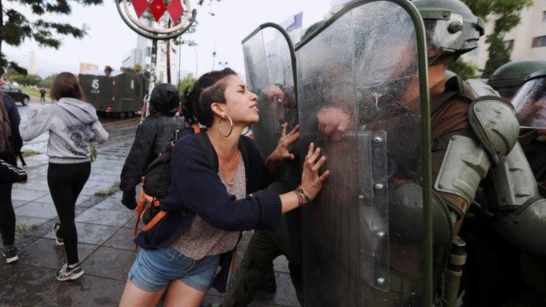 A Mapuche indigenous activist attempts to stop the movement of riot policemen during a protest demanding justice for Camilo Catrillanca, an indigenous Mapuche man who was shot in the head during a police operation, in Santiago, December 14, 2018.